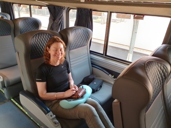 Sally demonstrating the size of the seats in coach class. They go back 45° and have leg rests that lever up. Lots of space between them but still pretty uncomfortable to try to sleep in.